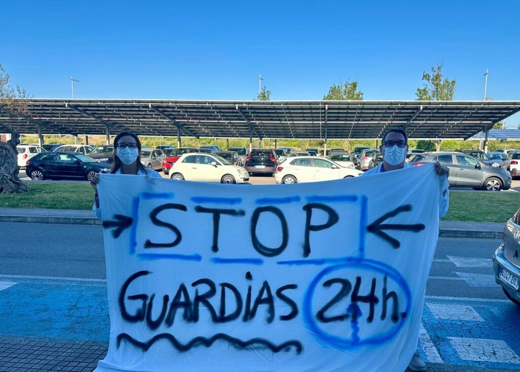 Dos médicos del Hospital Mateu Orfila sostienen una pancarta en la que se lee “STOP GUARDIAS 24h.” durante la huelga de facultativos en Menorca.