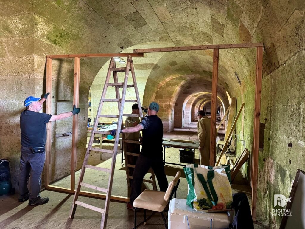 Varios restauradores trabajando alrededor de una estructura de madera dentro del túnel abovedado.